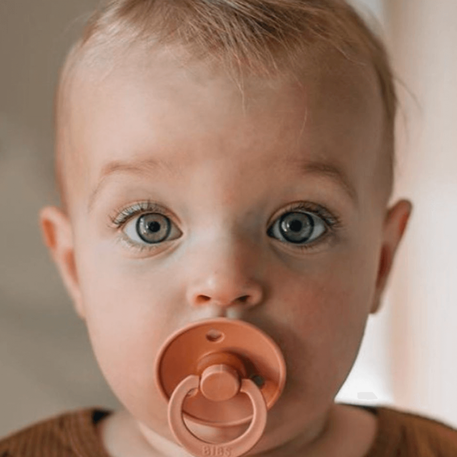 Kūdikis su bibs čiulptuku blush
