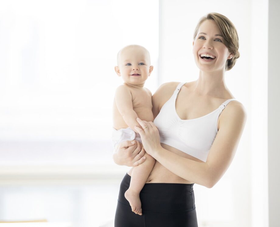 Laiminga mama su kūdikiu su balta medela liemenėle