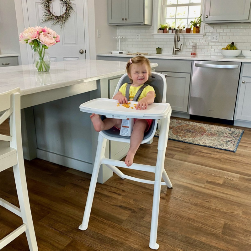 4MOMS Connect maitinimo kėdutė ir joje sėdinti mergaitė