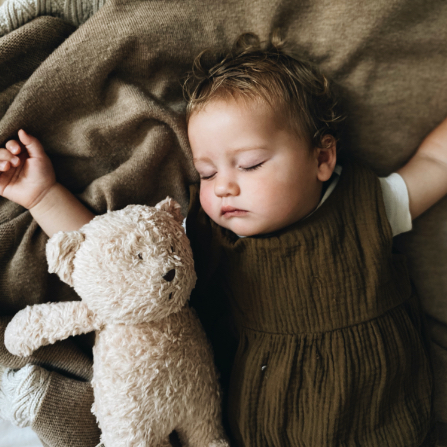 Miegantis kūdikis su žaislu