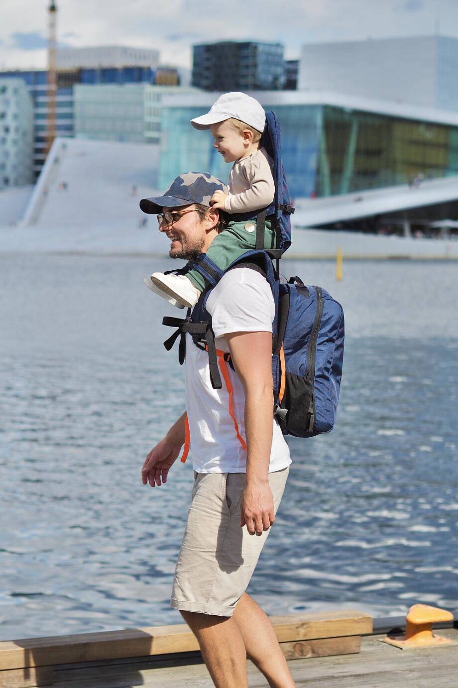 tėtis su vaiku - neša vaiką kelioninėje nešioklėje
