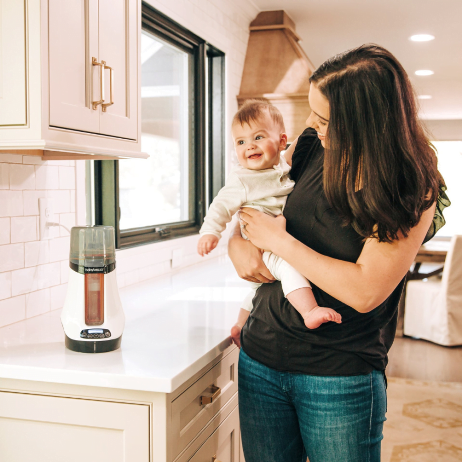 mama su laimingu kūdikiu virtuvėje prie šildytuvo
