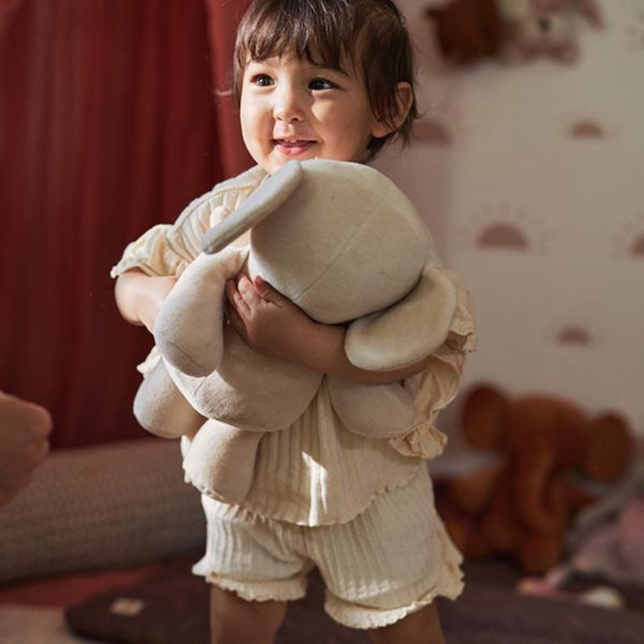 vaikas su minkštu žaislu drambliu