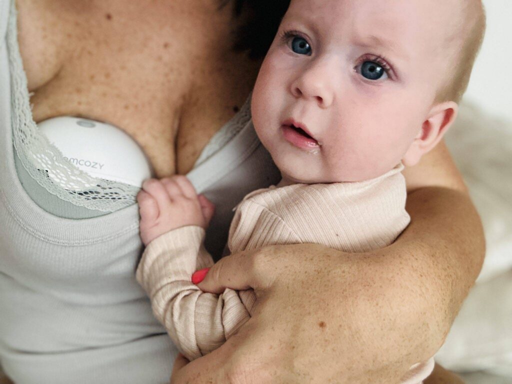 Mažylis ant mamos rankų ir mamoms krūtinė