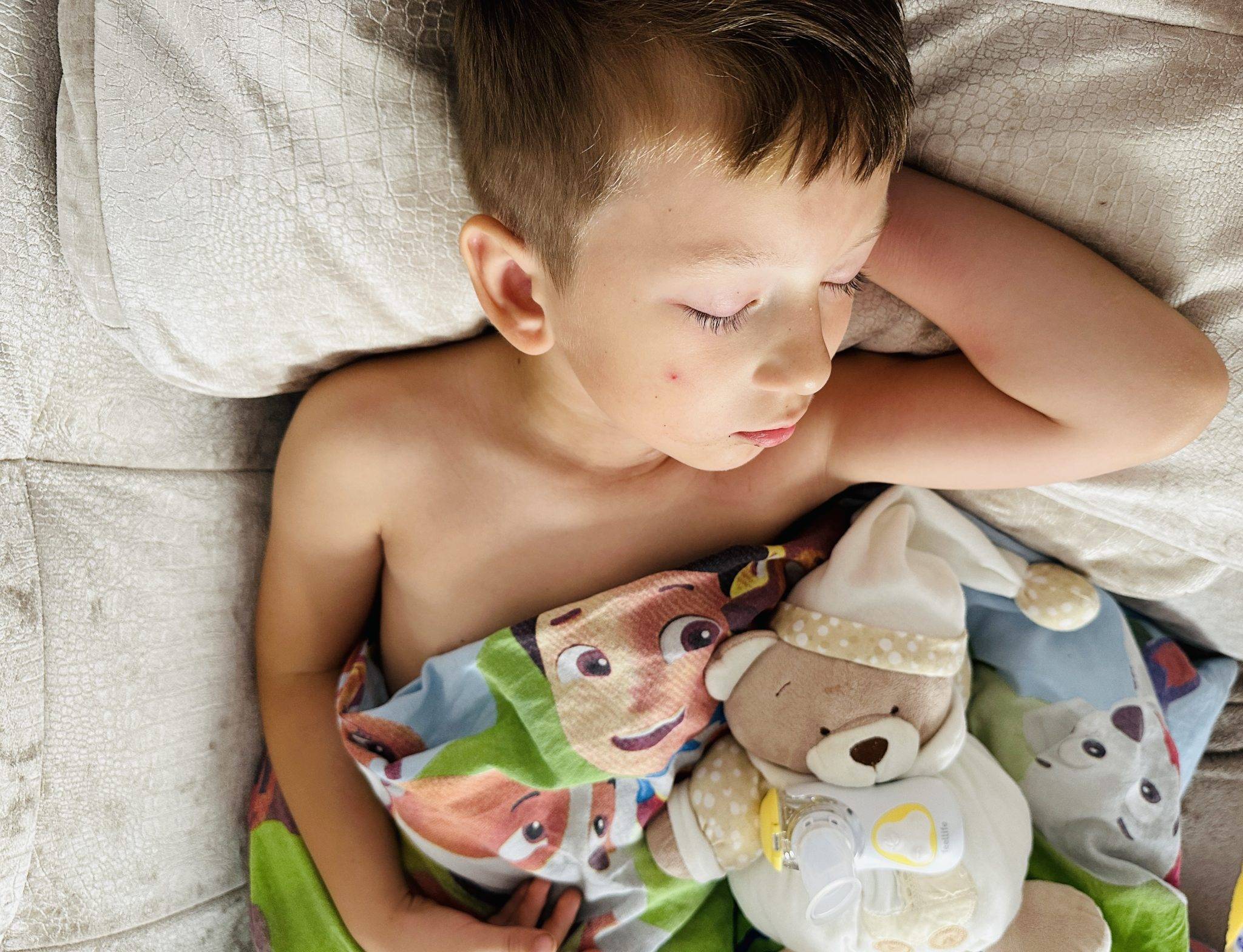 Miegantis vaikas su inhaliatoriumi