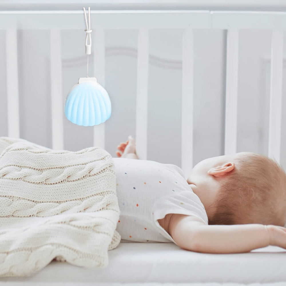 miegantis kūdikis su baltojo triukšmp aparatu