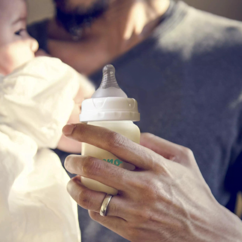 pieno buteliukas tėčio rankoje