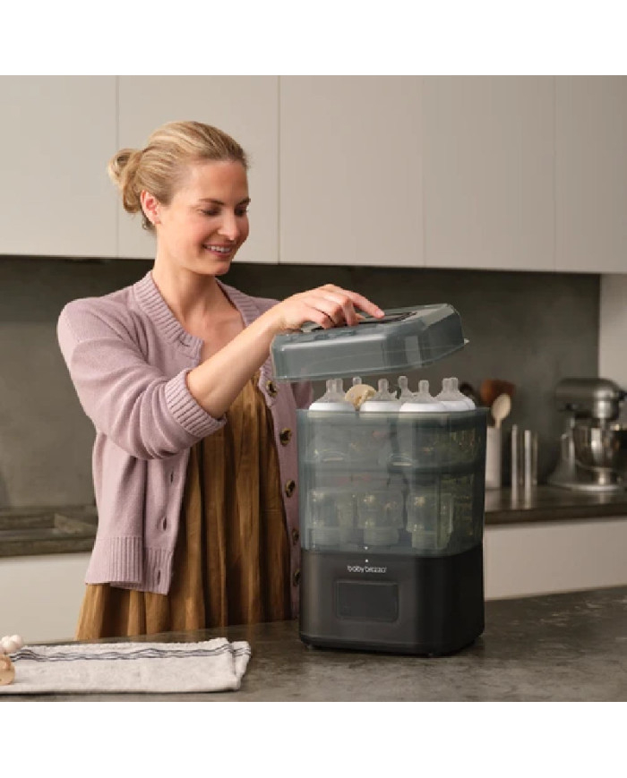 Moteris nuima Baby Brezza SuperQuick sterilizatoriaus dangtį virtuvėje