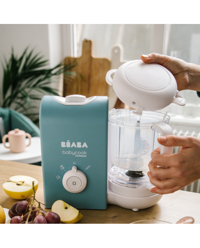 Moteris nuima BEABA Babycook Express dangtį virtuvėje šalia vaisių