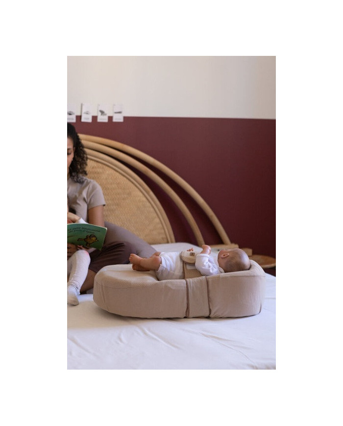 Kūdikis ilsisi Cocoonababy gultuke ant lovos šalia skaitančios mamos